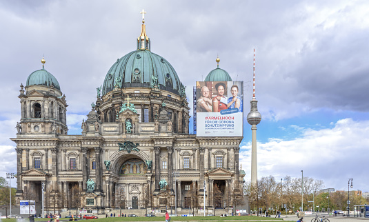 25.04.2021 Berlin, Germany  A poster of the vaccination campaign is attached to the Berlin Cathedral