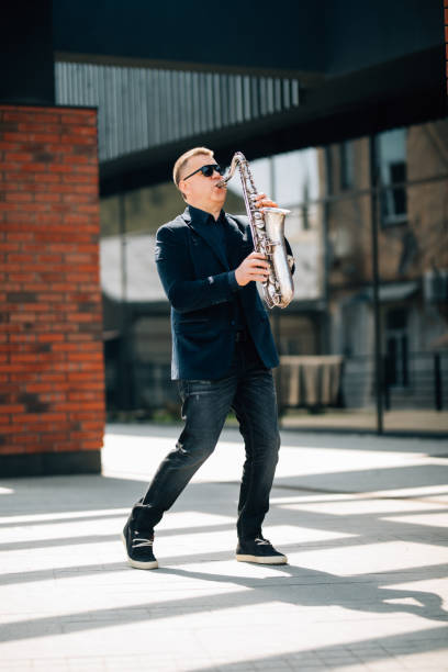 istock Middle age handsome man playing saxophone outdoors on the street 1315222106