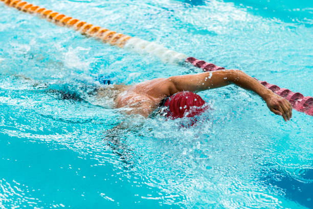 молодой спортивный человек, плавающий в олимпийском бассейне. - olympic athlete muscular build winning стоковые фото и изображения