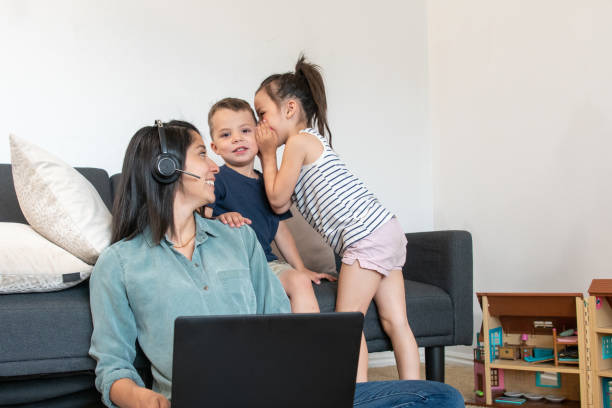 istock Young Mother on a Work Call While Her Children Sit With Her 1315224598