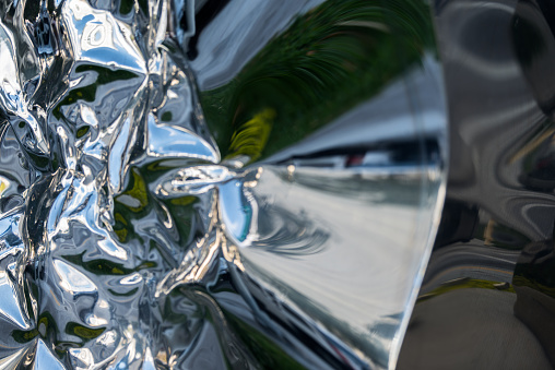 Distorted reflections of Miami on a damaged chrome surface.