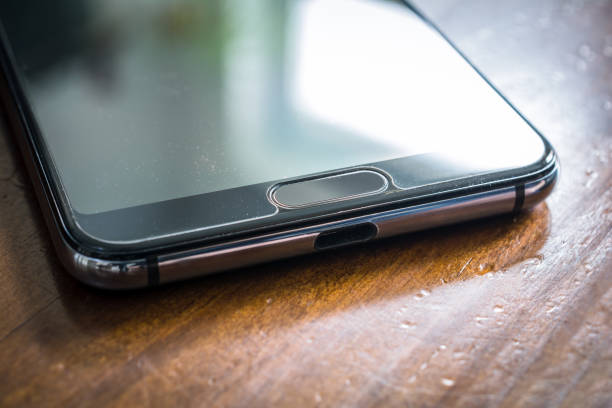 istock Black Smartphone With Window Reflection Lying On A Brown Wooden Table 1315225774