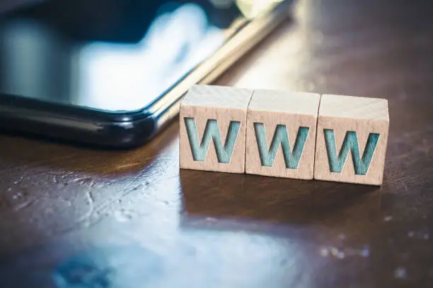 WWW Written On Wooden Blocks Next To Smartphone On A Table