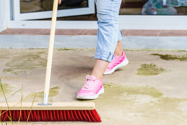 istock Woman using broom to clean up backyard patio 1315226307