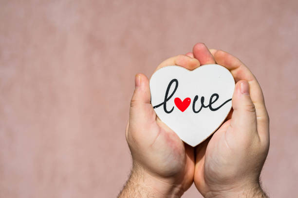 istock Hands holding heart with love message text. 1315226429