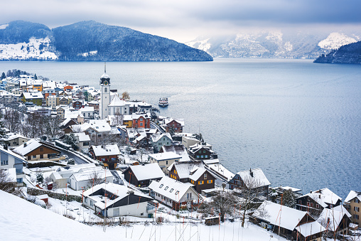 Lake Lucerne, Switzerland, view of Beckenried village and Alps mountains covered with white snow at winter timer