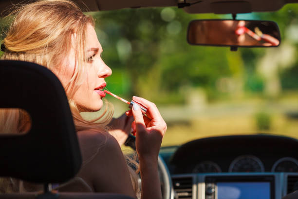 istock Girl apply make up while driving car. 1315227430
