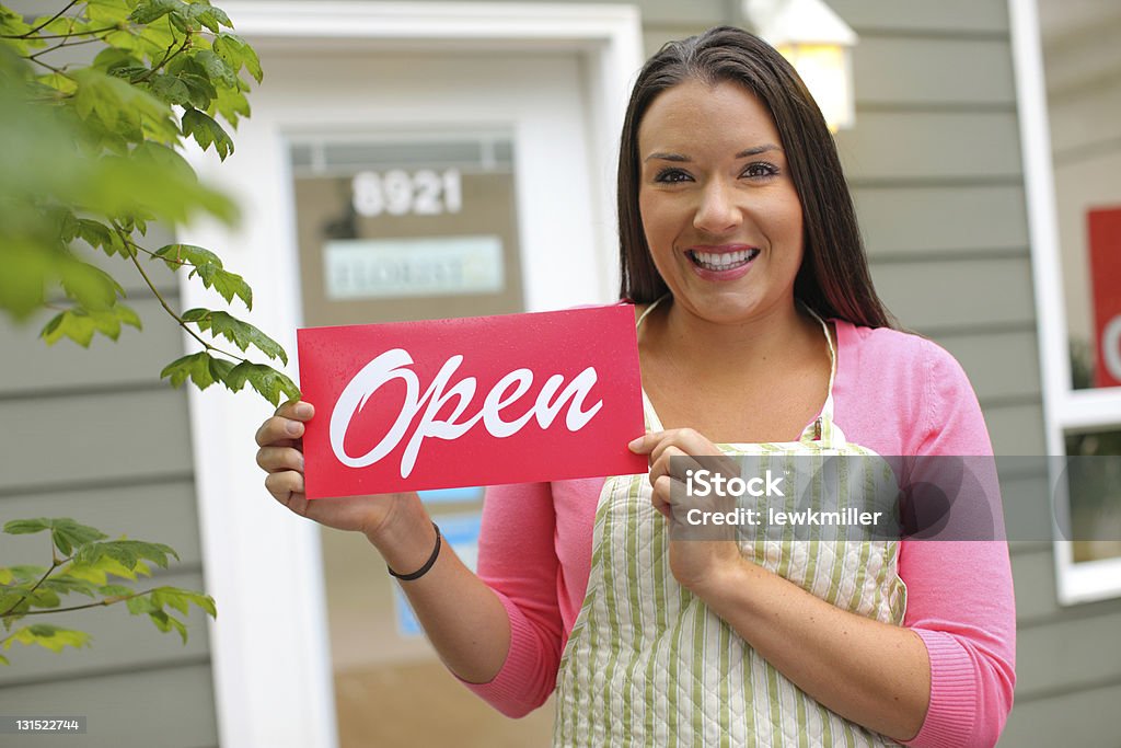 A portrait of a small business owner holding an open sign Portrait of small business owner holding OPEN sign Owner Stock Photo