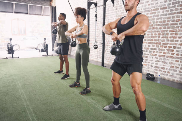 istock Shot of a fitness group using kettlebells while working out at the office 1315231381