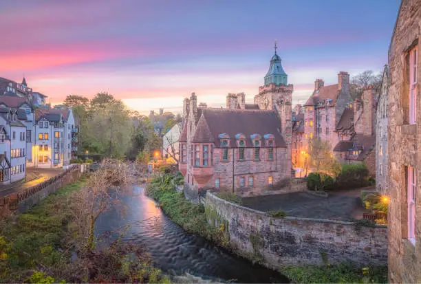 Vibrant, colourful sunset or sunrise sky over the historic architecture of Dean Village along the Water of Leith in Edinburgh, Scotland.