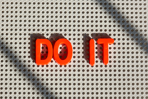 Meaningful words with single letters concept: Collection of plastic ABC learning toy letters on grey board. Light creating shadows. Creative design with copy space