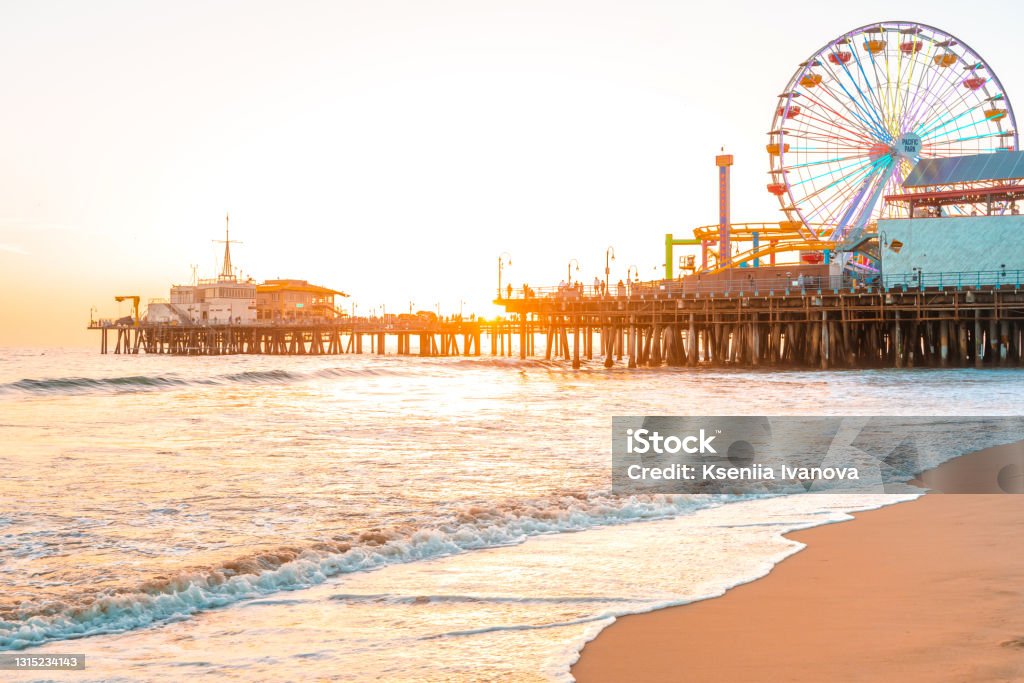 Santa Monica Pier on the background of an orange sunset, calm ocean waves, Los Angeles, California Santa Monica Stock Photo