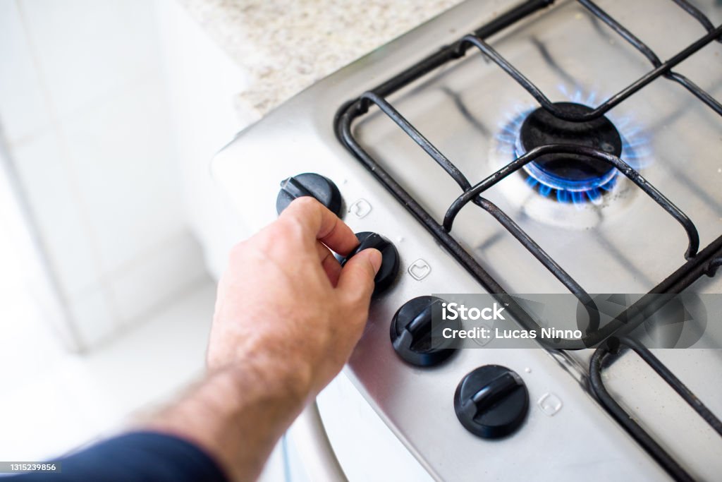 Cooking gas - lighting stove Hands of a man turning knob to light a gas stove Gas Stock Photo