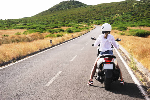 красивая девушка на скутере в горах. португалия, мадейра. - motorcycle women helmet sensuality стоковые фото и изображения