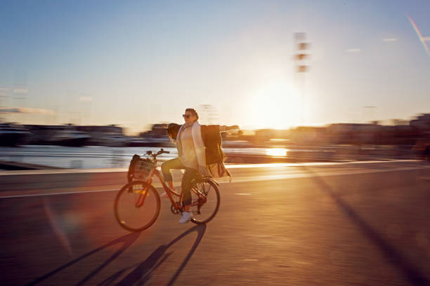 Young woman is riding bicycle without hands at the harbor