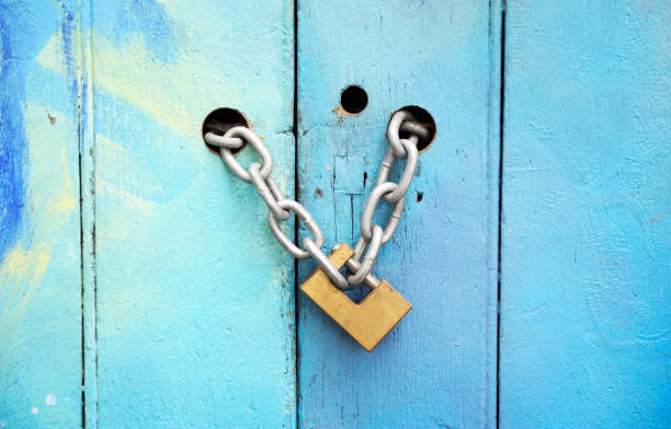istock An old lock on a chain hangs on old vignette bright colorful doors. 1315242682
