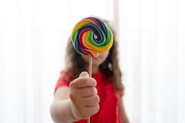 istock Little girl with candy close up 1315242699