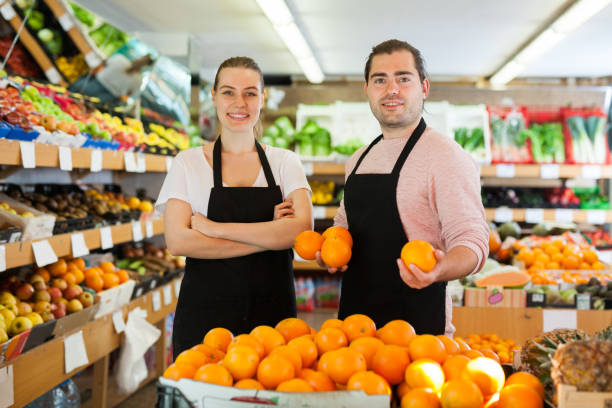 istock Young man and woman wearing aprons holding fresh oranges 1315246564