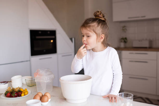 istock Child girl making cupcakes indoors 1315248655