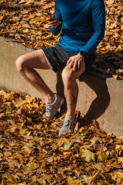 istock Anonymous Man Taking a Break from Exercising, Sitting in the Park and Using his Mobile Phone 1315251309
