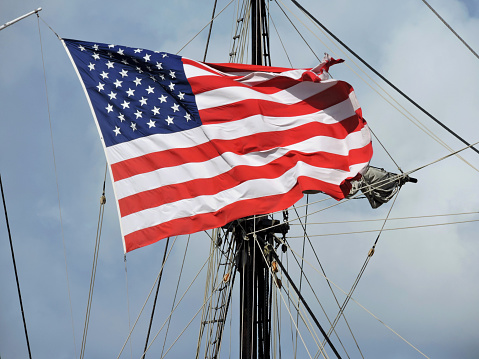 American flying flying on a ship against it's mast.