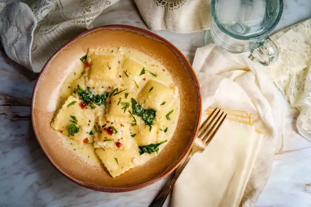 Cheese ravioli in a Tuscan creamy sauce with spinach and crushed red pepper