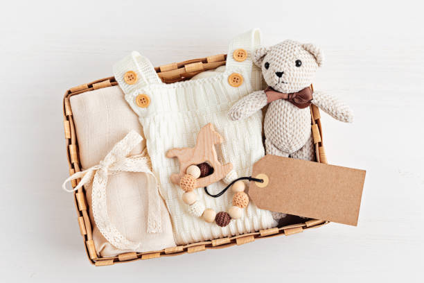 cesta de regalo con prenda y accesorios para bebés neutros de género. caja de cuidado de ropa orgánica de algodón recién nacido - ropa de bebé fotografías e imágenes de stock