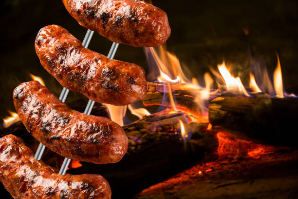 istock Sausages on the barbecue spit with flames 1315256132