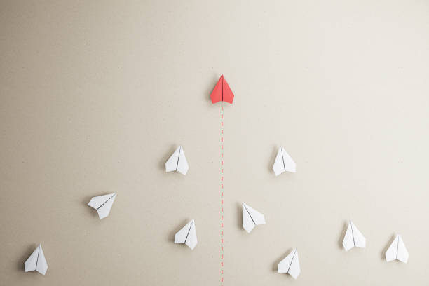 istock Success goal and creative idea concept with red paper plane compete with white paper planes on abstract beige wallpaper 1315257840