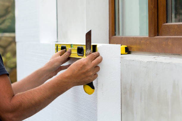 istock Construction worker insulating house wall with styrofoam insulatuion sheet. 1315258109