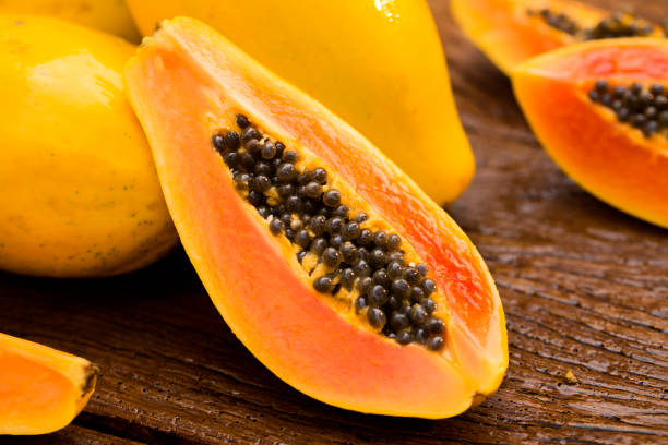istock Sliced fresh papaya on wooden background 1315258768