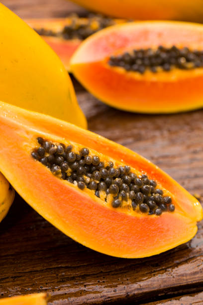 istock Sliced fresh papaya on wooden background 1315259214