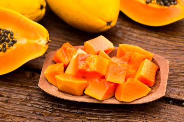 istock Sliced fresh papaya on wooden background 1315259277