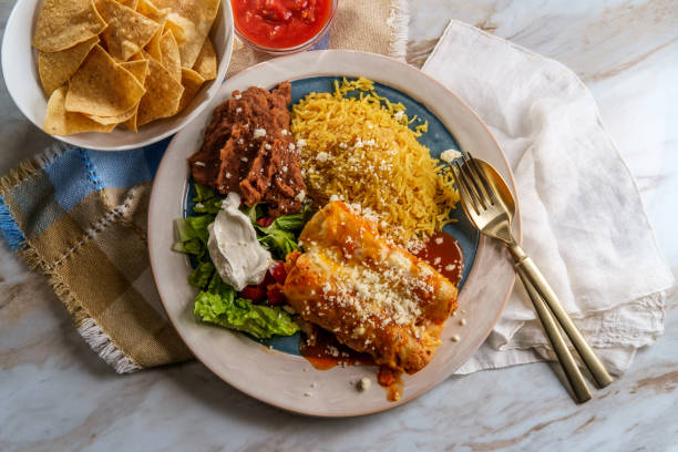 Mexican Enchiladas Dinner Traditional Mexican enchiladas dinner served with rice and refried pinto beans enchilada stock pictures, royalty-free photos & images