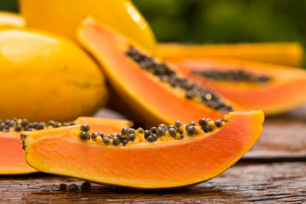 istock Sliced fresh papaya on wooden background 1315259616