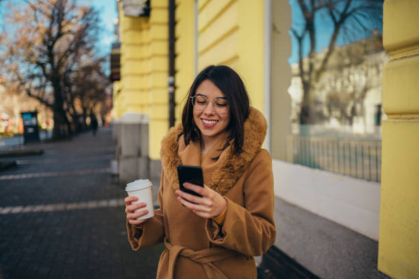 istock Young hispanic woman using a smartphone while drinking coffee takeaway 1315259804
