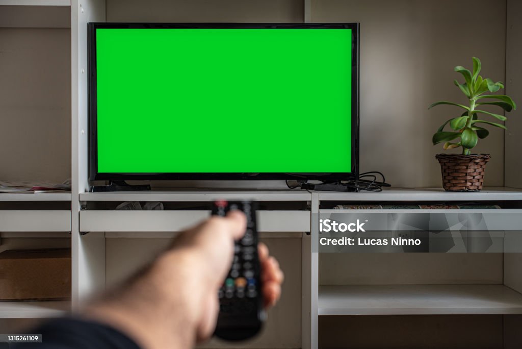 Remote control and LCD screen TV - Chroma Key Pointing remote control towards a TV at home- Chroma Key Television Set Stock Photo