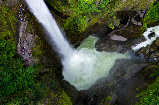 Aerial view of el pailon del diable with many tourist at the small terrace next to the waterfall