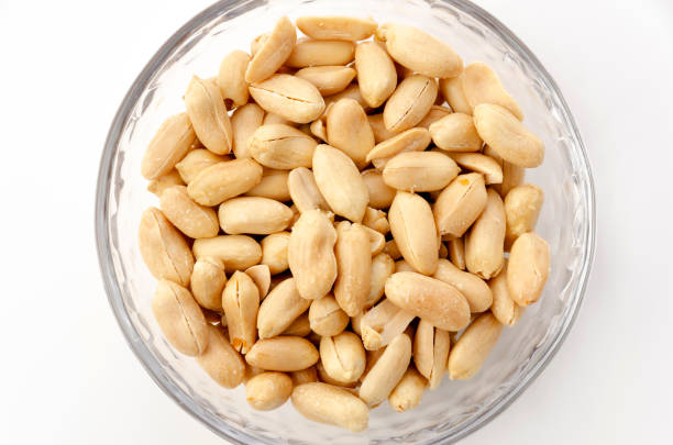 istock Roasted salted peanuts in a transparent glass bowl on a white background 1315272695