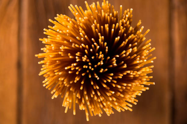 Yellow long spaghetti on a rustic background. Yellow italian pasta. Long spaghetti. Raw spaghetti bolognese. Raw spaghetti , Food background concept.