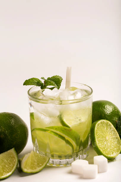 caipirinha - brazilian's national cocktail made with cachaca, sugar and lemon or lime, isolated on white background - caipiroska imagens e fotografias de stock
