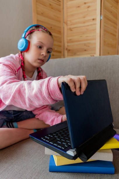 istock Girl work on laptop while sitting the sofa in room at home. Concept education is process teaching at school. 1315293911