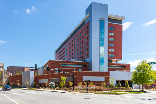 Asheville, NC, USA-25 April 2021: Mission Hospital, corner of Biltmore and Hospital Drive.  Sign and building.  blue sky, spring day.