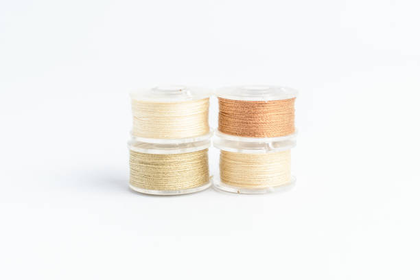 istock Different spools of mixed beige and brown cotton thread prepared for sewing machine, isolated on white, side view 1315314124