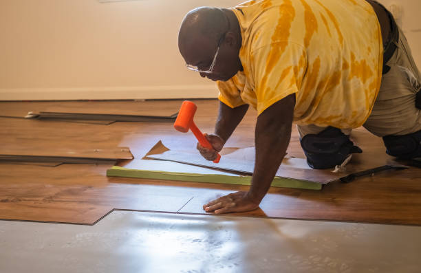 istock African American carpenter installing new laminated floor in room 1315317515