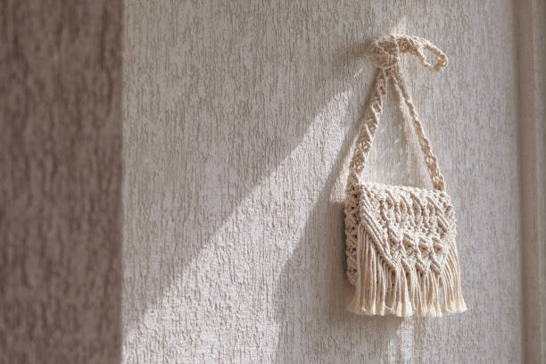 istock Handmade macrame bag  on the light wall. ECO friendly natural macrame cotton bag. Hobby knitting handmade macrame. Modern summer concept. Copy space 1315318792