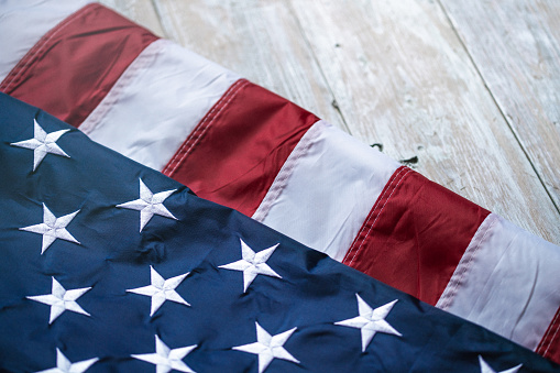 Flag of USA on light grey wooden background.\nEmpty space provided for text placement for US celebrations such as: Memorial Day, Independence Day, etc.