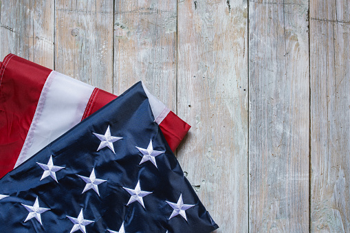 Flag of USA on light grey wooden background.\nEmpty space provided for text placement for US celebrations such as: Memorial Day, Independence Day, etc.