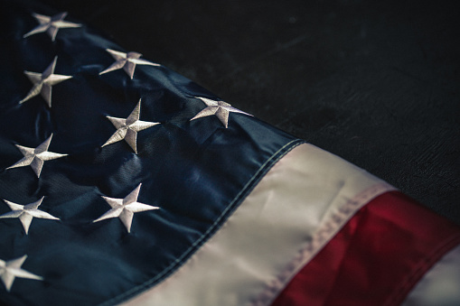 Flag of USA on dark concrete background.\nEmpty space provided for text placement for US celebrations such as: Memorial Day, Independence Day, etc.
