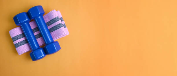 istock Blue dumbbells and copy space on yellow background. Healthy lifestyle. 1315320265